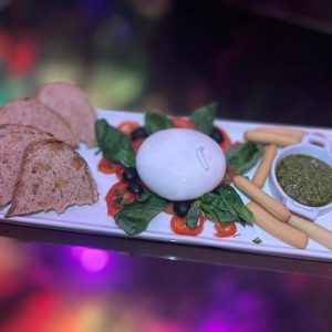 Burrata fresca con acompañamientos mediterráneos para una experiencia ligera.