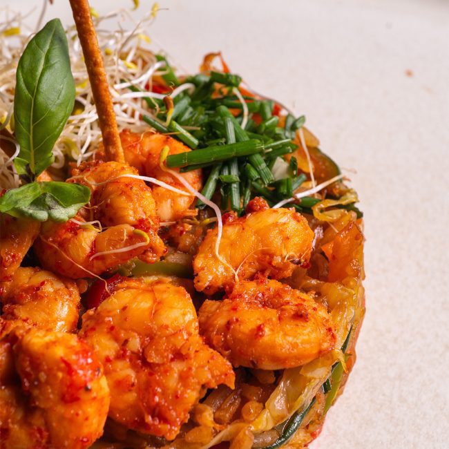 Arroz salteado con gambas y vegetales en salsa asiática.