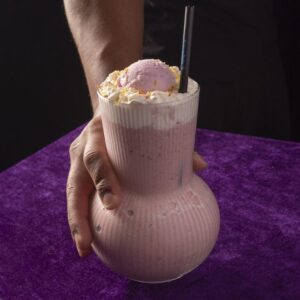 Batido con frutos rojos y helado de nata, coronado con licor de madroño.