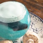 Poción Agua: cóctel de piña, flor azul y espuma cítrica. Una ola en copa que susurra secretos del mar con cada burbuja.