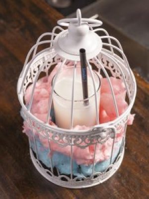 Cóctel Poción Aire: nube líquida de chocolate blanco, coco y almendra. Servido en jaula encantada con algodón de azúcar.