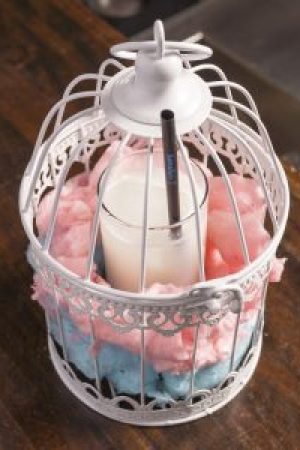 Cóctel Poción Aire: nube líquida de chocolate blanco, coco y almendra. Servido en jaula encantada con algodón de azúcar.