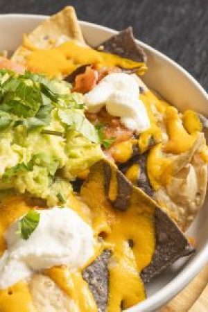 Nachos mágicos sin gluten con mezcla de quesos y guacamole.