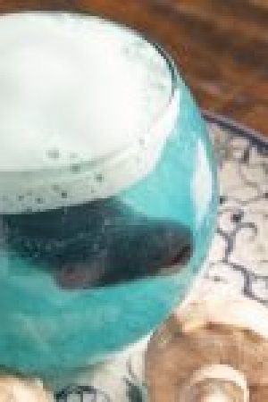 Poción Agua: cóctel de piña, flor azul y espuma cítrica. Una ola en copa que susurra secretos del mar con cada burbuja.